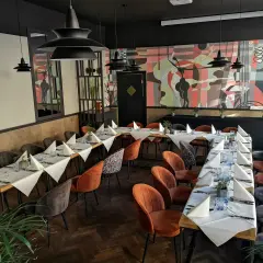 Elegancka sala bankietowa z nakrytymi stołami, idealna na wyjątkowe okazje. To może być najlepsza restauracja w Olsztynie.