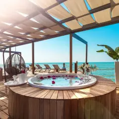Luksusowy jacuzzi z płatkami róż na tarasie z widokiem na morze. Idealne miejsce na relaks w stylu ultra all inclusive.