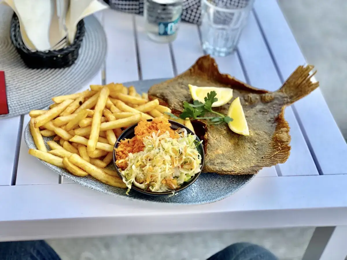 Smażona ryba z frytkami i surówką, idealny posiłek w jednej z kołobrzeg restauracje.