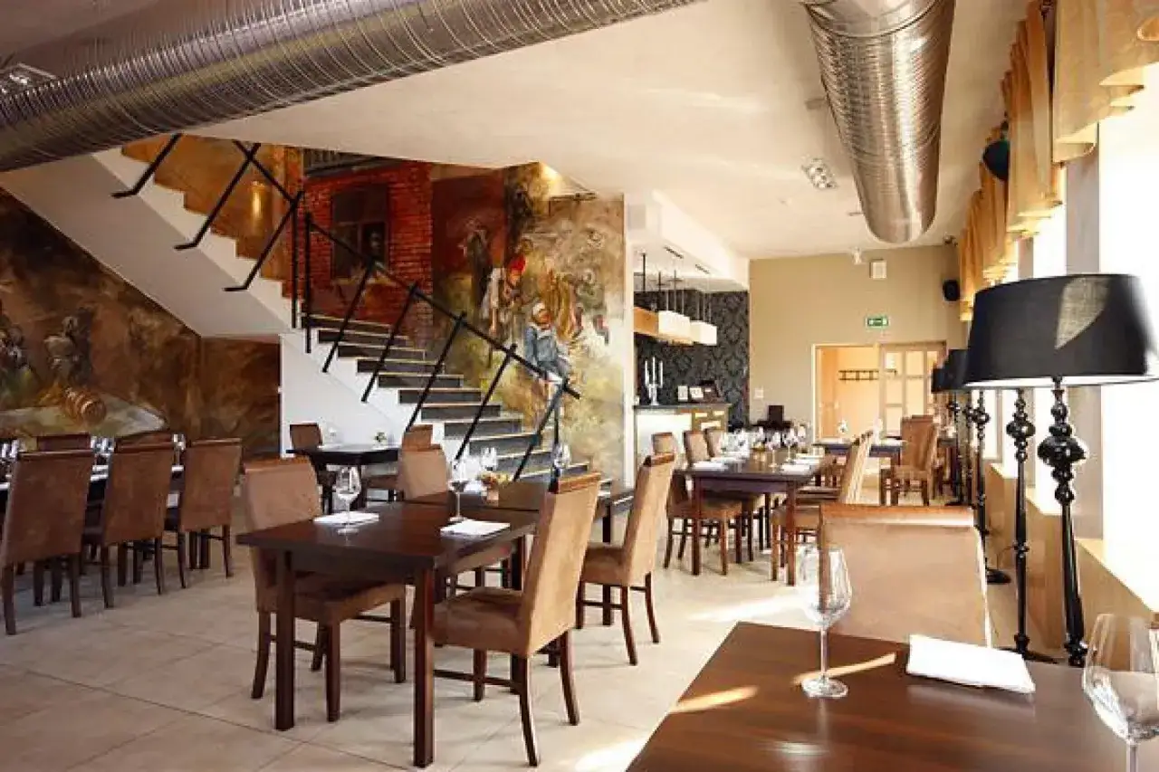 Elegancka restauracja w Gdańsku z muralem na ścianie i schodami. Idealne miejsce, gdzie zjeść w Gdańsku.